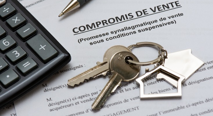 Vente immobilière – des clés et une calculatrice sur un compromis de vente