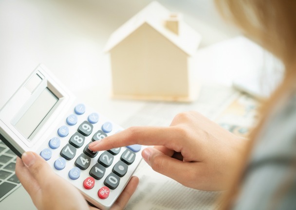 Vente immobilière – une femme faisant un calcul sur une calculatrice