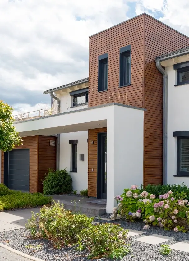 Achat maison – une maison moderne et contemporaine en pierre et en bois avec son garage et ses parterres fleuris