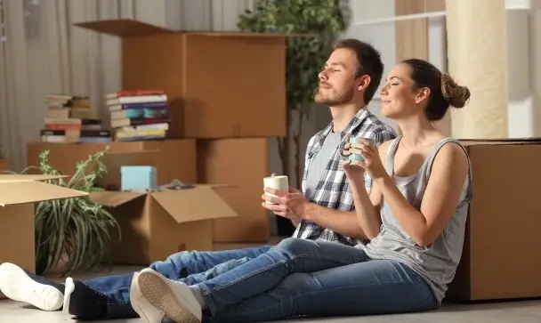 Assurance charges copropriété impayées – un couple assis par terre venant d’emménager