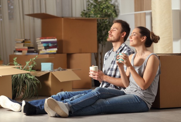 Location appartement – un couple assis par terre en plein emménagement
