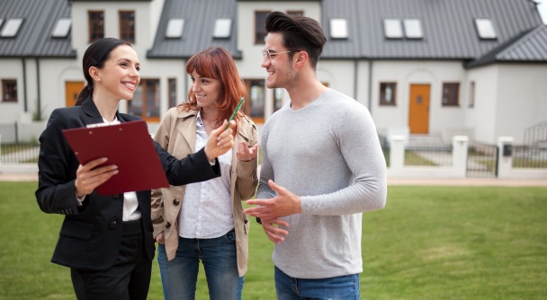 Louer une maison – un couple faisant une visite immobilière avec un agent dans une zone résidentielle et pavillonnaire