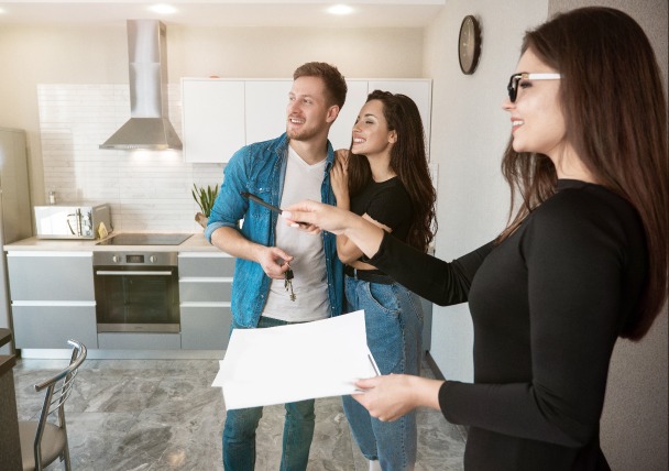 Louer un logement – un couple visite un appartement à louer avec un agent immobilier