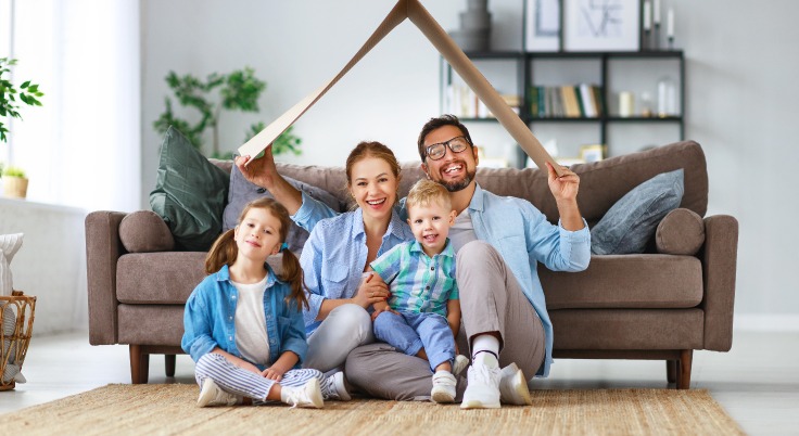 Acheter dans l’immobilier – une famille heureuse assise sur le sol de son salon