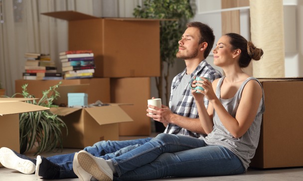 Assurance charges copropriété impayées – un couple assis par terre venant d’emménager