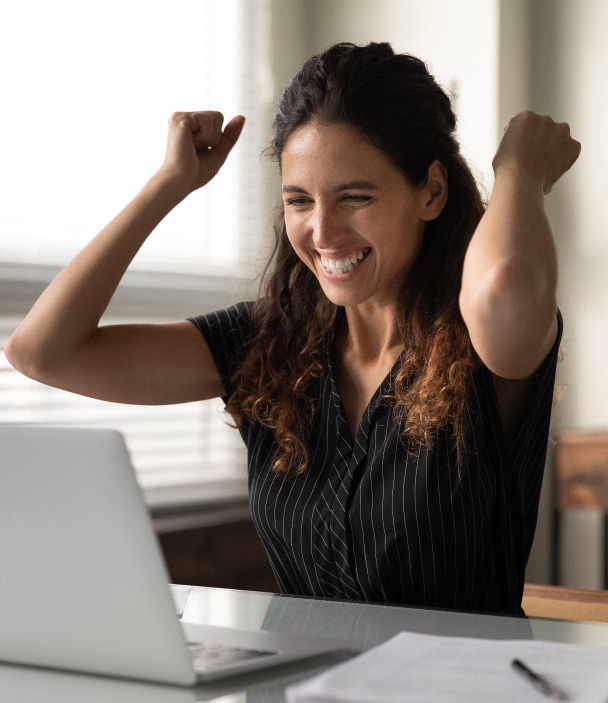 Mandat de vente – une femme souriante et heureuse devant son ordinateur